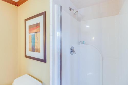 a bathroom with a toilet and a picture on the wall at Spacious Cabin with Private Dock on White River! in Flippin