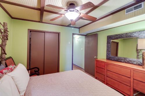 a bedroom with a ceiling fan and a dresser with a mirror at Spacious Cabin with Private Dock on White River! in Flippin