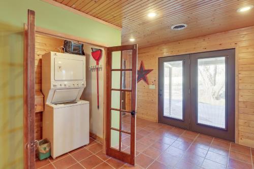 a kitchen with a refrigerator and a door in a room at Spacious Cabin with Private Dock on White River! in Flippin