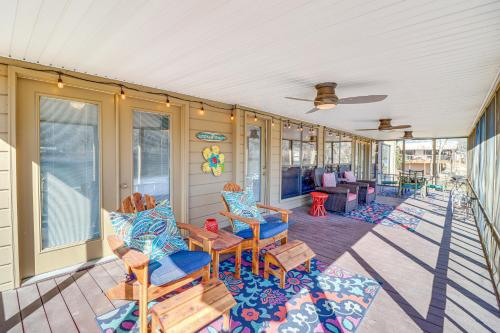 a covered porch with chairs and a couch at Spacious Cabin with Private Dock on White River! in Flippin