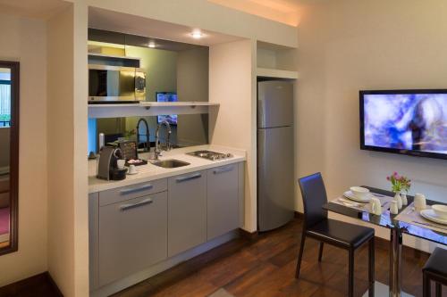 a kitchen with a sink and a table with chairs at Las Suites Campos Eliseos in Mexico City
