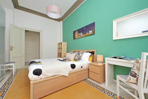 una camera da letto con un letto e una scrivania di CASA GIULIANA - 3BR 2BATH, 2nd floor of historic mansion with lift and doorman, comfortable, chic, family friendly, 600 meters from Vatican & Ottaviano metro, quietest area of P R A T I wealthy, secure, accessible district - Warm guest care in 4 languages a Roma
