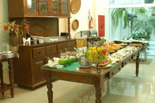 a table with a bunch of food on it in a kitchen at Hotel Amantykir in Itajubá