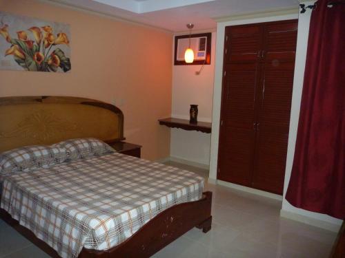 a bedroom with a bed and a window and a door at Residencial El Amanecer in Panama City