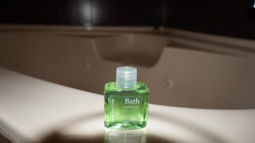a green bottle of soap sitting on top of a bed at Residencial El Amanecer in Panama City