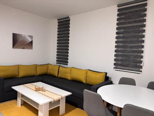 - un salon avec un canapé et une table dans l'établissement Apartment Grey Deluxe, à Sarajevo