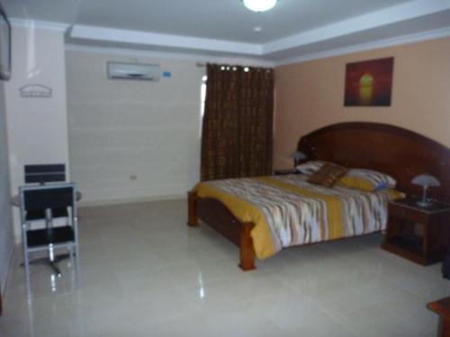 a bedroom with a bed and a chair in it at Residencial El Amanecer in Panama City