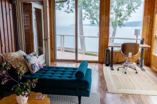 a living room with a blue couch and a table at Luxury Beach Home Ocean View Sonos in Langley