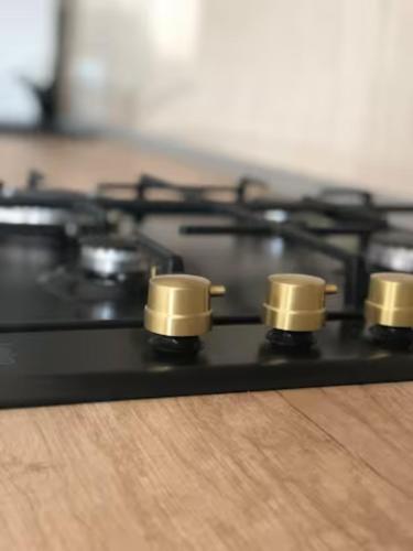 a black stove top with gold knobs on it at Best Apartment Suceava in Suceava