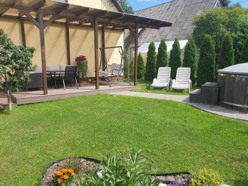a backyard with a gazebo with chairs and a table at Лора in Lapmežciems