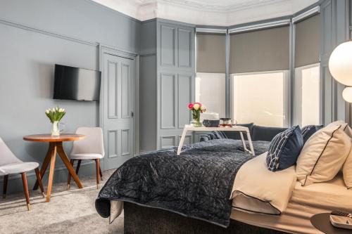 a bedroom with a bed and a table and chairs at Bluebell Studio Glasgow Airport in Paisley