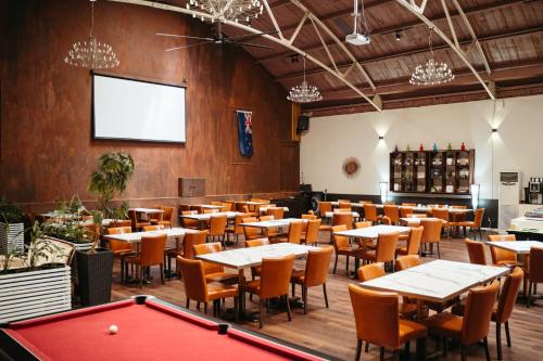 a restaurant with tables and a pool table at Auckland City Hotel - Hobson St in Auckland