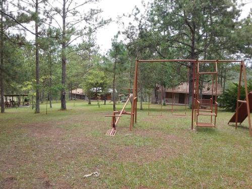 an empty park with a swing set in the grass at Cabaña La tortuga in Siguatepeque
