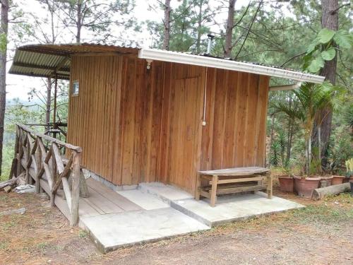 a small wooden building with a bench next to it at Cabaña La tortuga in Siguatepeque