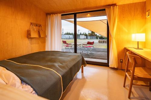 Shirahama Kousha - Vacation STAY 41977v في Hongō: غرفة نوم مع سرير وبلكونة مع طاولة وكراسي