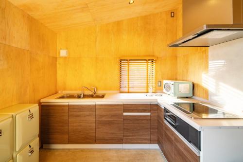 a kitchen with wooden cabinets and a sink at Shirahama Kousha - Vacation STAY 41977v in Hongō