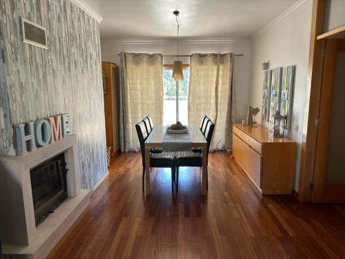 a dining room with a table and a fireplace at Apartamento Familiar T3 em Valongo com Terraço Privativo e Churrasqueira in Campo