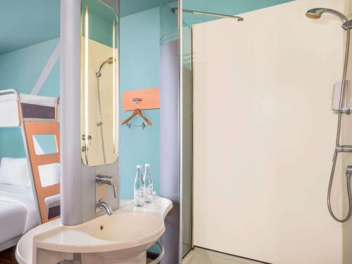 a bathroom with a sink and a shower at Ibis Budget Jakarta Airport in Tangerang