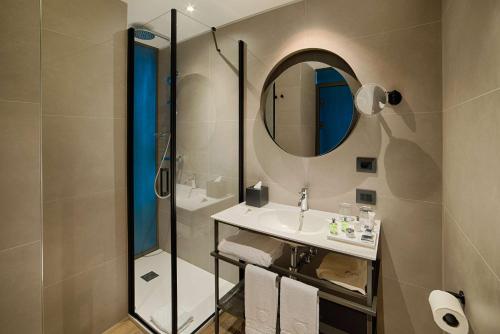 a bathroom with a sink and a mirror at NH Collection Murano Villa in Murano