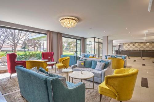 a lobby with blue and yellow chairs and tables at Radisson Hotel Plovdiv in Plovdiv