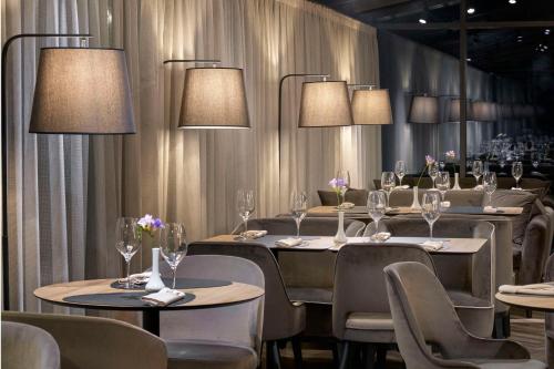 a dining room with tables and chairs and lights at Radisson Hotel Plovdiv in Plovdiv