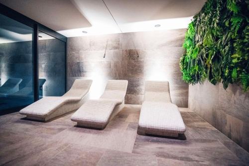 a waiting room with three white benches and plants at Radisson Resort Kołobrzeg in Kołobrzeg