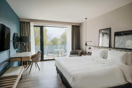 a hotel room with a large bed and a desk at Radisson Resort Kołobrzeg in Kołobrzeg