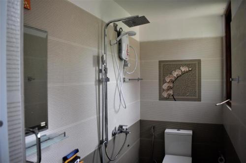 une douche dans une salle de bain avec toilettes et lavabo dans l'établissement Rock View Home, à Kandy