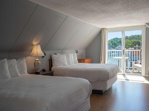 2 camas en una habitación de hotel con ventana en Fisherman's Wharf Inn, en Boothbay Harbor