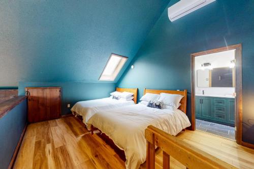 2 letti in una camera con pareti blu di Manchester Ski Chalet a Manchester