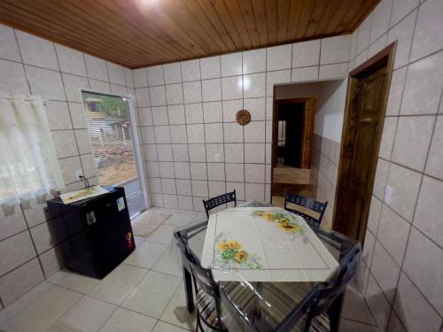 a kitchen with a table and chairs in a room at Casa Jardinada in Pomerode