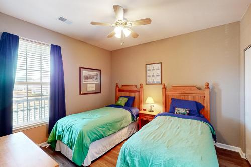 a bedroom with two beds and a ceiling fan at Sunset Paradise in Sunset Beach