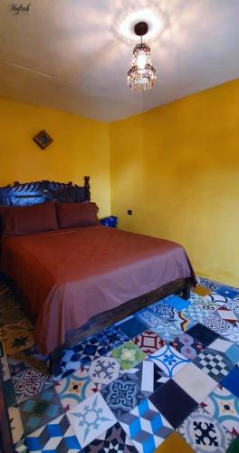 a bedroom with a bed with a colorful floor at Casa Hamidane in Chefchaouene