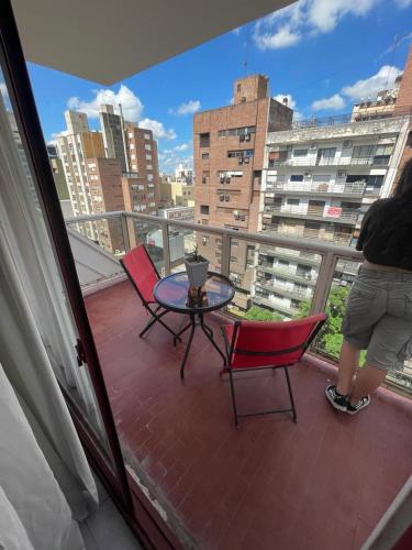 a person standing on a balcony with a table and chairs at Chacabuco 36 in Córdoba