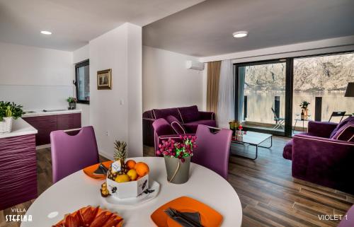 a living room with a table and purple chairs at Villa Stefina in Kotor