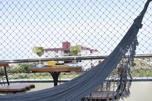 a fence with a hammock and a table with chairs at Top Ap 3 Qts, todos com Ar Cond e TV, a 3 Qd da orla Sua família sem aperto Não sofra férias, desfrute-as in Aracaju