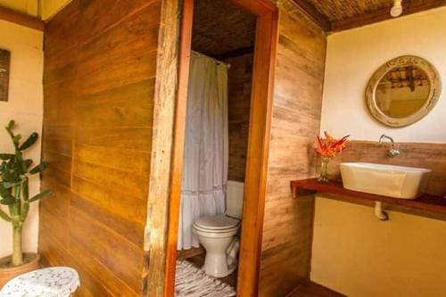 a bathroom with a toilet and a sink at Refúgio Farm House in Paraty