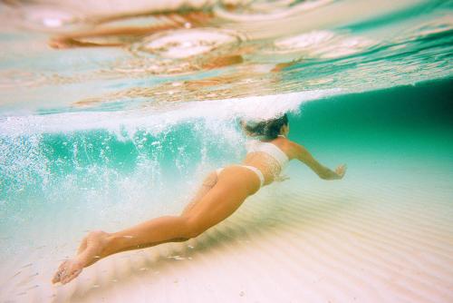 a woman in a bikini swimming on the beach at Casa Tinti in Tintipan Island