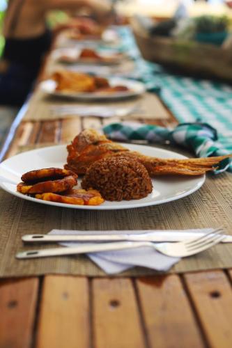 a table with plates of food on a wooden table at Casa Tinti in Tintipan Island