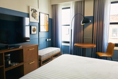 a hotel room with a bed and a tv and a chair at Hotel Julian in San Francisco
