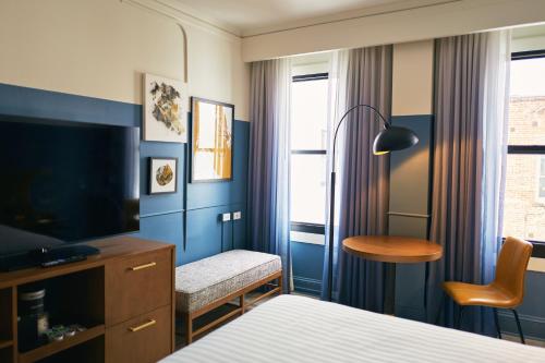 a hotel room with a bed and a desk and a television at Hotel Julian in San Francisco