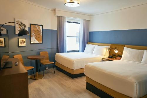 a hotel room with two beds and a table and chairs at Hotel Julian in San Francisco
