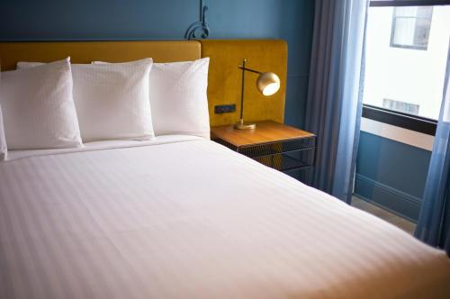 a bedroom with a large white bed with a window at Hotel Julian in San Francisco
