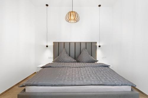 a bedroom with a large bed with a chandelier at SmartApart Julia in Tettnang
