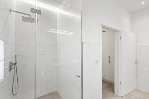 a shower with a glass door in a bathroom at Premium 24h SmartApart Modern mit Smarthome zentral-Welcome drink inkl in Tettnang