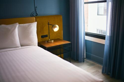 a bed with a lamp on a nightstand next to a window at Hotel Julian in San Francisco