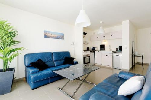 un salon avec un canapé bleu et une table dans l'établissement Super T2 Climatisé avec Balcon à pied plage Catalan, à Marseille