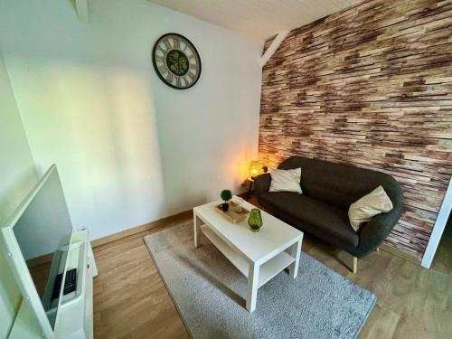 a living room with a couch and a table at Appartement chaleureux in La Roche-sur-Yon