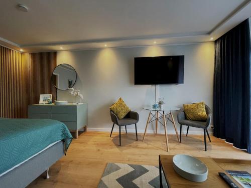 ein Hotelzimmer mit einem Bett und einem Tisch und Stühlen in der Unterkunft Haus Vier Jahreszeiten am See Vier Jahreszeiten - HS 221 in Goslar