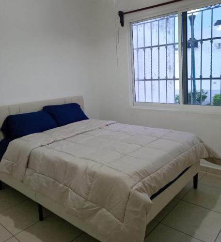 uma cama num quarto branco com uma grande janela em A 5 MINUTOS DEL CORAZON DE TACNA em Tacna